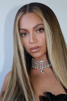 a woman with long blonde hair wearing a choker necklace and black dress at an event