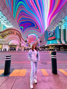 a woman standing in front of a colorful ceiling at the las vegas resort and casino