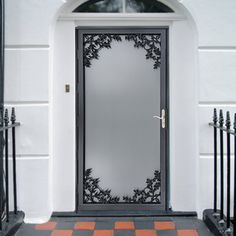 a black and white door with an ornate design on the front entrance to a house