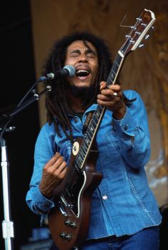 a man with dreadlocks playing an electric guitar