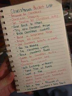 someone holding up a christmas bucket list