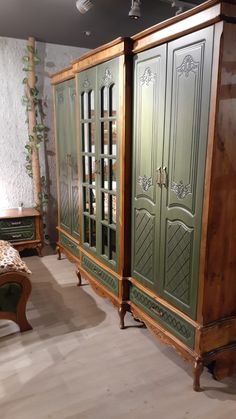 an antique armoire with green doors in a room