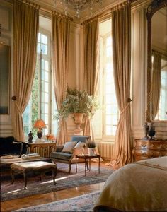 a living room filled with lots of furniture and windows next to a chandelier