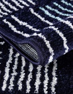 a close up view of a blue and white rug with stripes on the bottom half