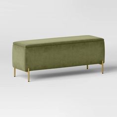 an upholstered bench with wooden legs and a green fabric cover on the back