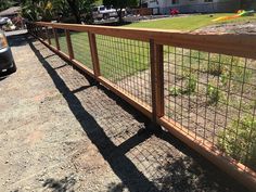 a car parked next to a fence on the side of a road in front of a house