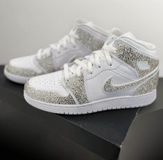 ** PLEASE PLACE YOUR SHOE SIZE IN THE PERSONALIZATION BOX  Where luxury meets style with our custom rhinestoned Nike Air Jordan 1 sneakers, elevate your footwear game with our meticulously crafted designs, blending iconic streetwear with dazzling sophistication. Each pair is meticulously adorned with premium rhinestones, creating a striking statement piece that exudes unparalleled elegance. Whether you're a sneaker aficionado or a fashion-forward trendsetter, our unique creations promise to elevate your look with unmatched flair. Step into the extraordinary and make a lasting impression with our custom rhinestoned Nike Air Jordan 1 sneakers. Luxury High-top Sneakers With Rhinestones, Luxury White Sneakers With Rhinestones, White Iced Out Sneakers For Streetwear, White Embellished Sneakers For Streetwear, White Low-top Custom Sneakers With Bling, White Custom Sneakers With Rhinestones For Streetwear, White Custom Rhinestone Sneakers For Streetwear, White Rhinestone Custom Sneakers For Streetwear, White Rhinestones Custom Sneakers For Streetwear