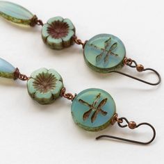 Beaded Czech Glass Dangle Earrings Fly away in style with these unique Dragonfly Flower Dangle Earrings. Featuring dreamy seafoam opaline Czech glass beads. Perfect for any nature lover, these earrings will have you buzzing with joy. Handmade with copper wire. 2.75 inches long Niobium Hypoallergenic Ear wires SKU #EAR021 Handmade in Maine Limited Edition Czech Beads Jewelry, Jewelry To Make, Czech Glass Jewelry, Beaded Jewelry Earrings, Flower Dangle Earrings, Whimsical Jewelry, Bead Projects, Stacked Earrings, Pretty Beads