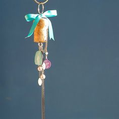 a wind chime hanging from a metal pole with a bow on it's head