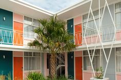 an apartment building with colorful balconies and palm tree