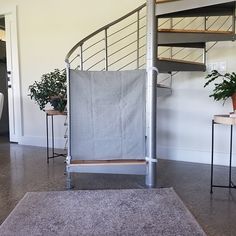 a living room with a spiral staircase and potted plants