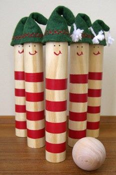 three wooden pegs decorated with christmas hats and candy canes on top of a table