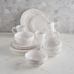 white dinnerware set on marble countertop with hexagonal tiles in the background