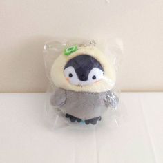 a small stuffed animal in a plastic bag on a table with a white wall behind it