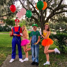 three people dressed up as mario and luigi with balloons