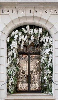 the entrance to a building with white flowers on it