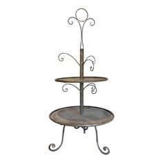 two tiered cake stand with wrought iron designs on each side and wood top for display