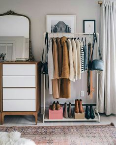 an organized closet with shoes and sweaters hanging on the rack, next to a dresser