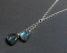 Double, blue-grey labradorite briolette pendant necklace wire-wrapped in sterling silver This lariat Y-style necklace features a drop pendant of two genuine, smooth, high-polished labradorite briolette-shaped gemstones, wire wrapped in sterling silver and suspended on a chain with a lobster claw clasp.  Gorgeous necklace for any occasion ! Details: necklace length:  choose at check-out large labradorite briolette: 12 mm small labradorite briolette: 10 mm sterling silver chain & clasp Thanks for visiting ! Back to my shop for more jewelry options: www.etsy.com/shop/krisatdesigns Raw Jewelry, Ethiopian Opal Jewelry, Single Pearl Necklace, Detailed Necklace, Y Necklace, Labradorite Necklace, Labradorite Jewelry, Labradorite Necklaces, Necklace Blue