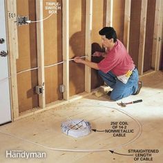 a man is working on the wall in his house with wires and plugs attached to it