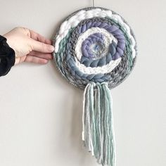 a hand holding a piece of art made out of yarn