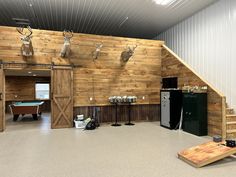 a room with some deer heads on the wall and a pool table in front of it