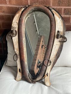 a mirror sitting on top of a bed next to a brick wall in a room