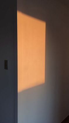 an empty room with the light coming in through the window on the wall and floor