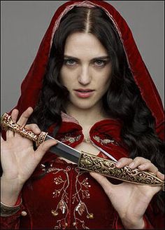 a woman dressed in red holding a knife