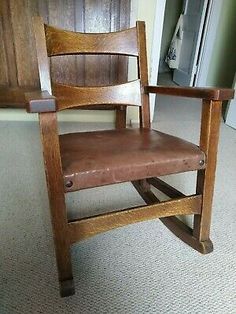 a wooden chair with brown leather seat and backrests in front of a door