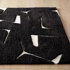 a black and white rug on top of a wooden floor