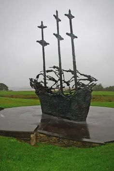 a boat sculpture sitting on top of a lush green field