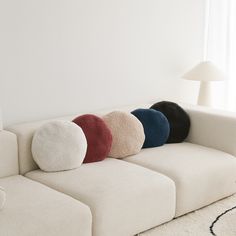 a white couch with four different colored pillows on it