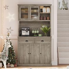 a christmas tree is in front of a wooden hutch with bottles and spices on it