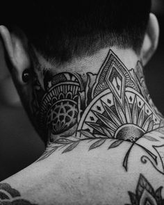 black and white photograph of a man's neck with tattoo designs on his neck