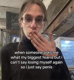 a woman wearing glasses is making a funny face while holding her hands to her mouth