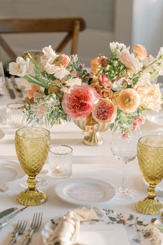 the table is set with flowers and silverware