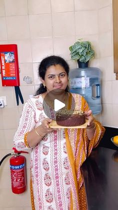 a woman holding a plate with a piece of cake on it