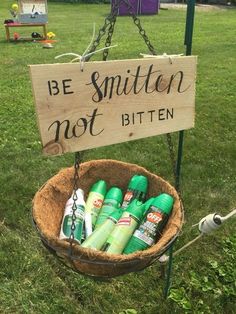 a wooden sign that says be smitten not bitten in front of some bottles