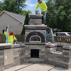 a man standing on top of a brick oven