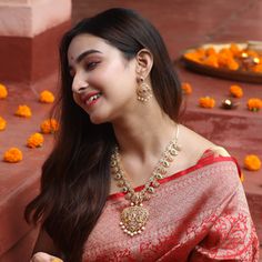 a woman in a red sari is smiling