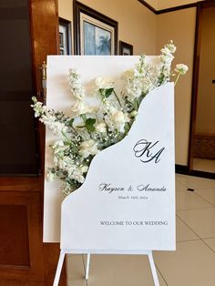 a welcome sign with white flowers on it