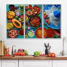 three pictures of food on the wall above a kitchen counter with utensils and bowls