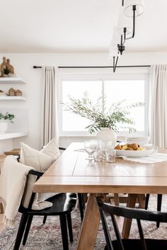 a dining room table with chairs and plates on it