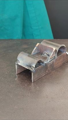 a metal object sitting on top of a table next to a blue wall and floor