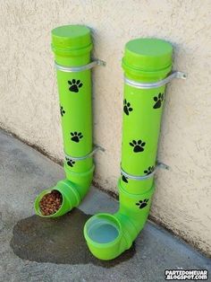 a pair of green boots with paw prints on them and a dog food dish in the bottom