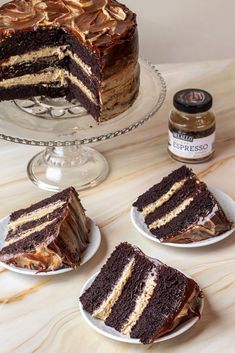 three slices of chocolate cake on plates with peanut butter and jelly spread around the edges