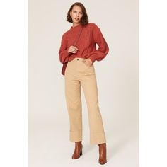 a woman in red sweater and tan pants