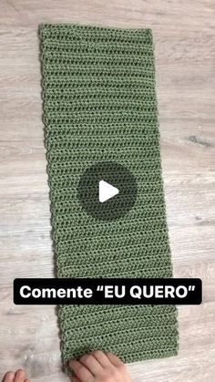 someone is holding up a green crocheted blanket with the words commente eu quero on it