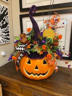 a decorated pumpkin sitting on top of a dresser